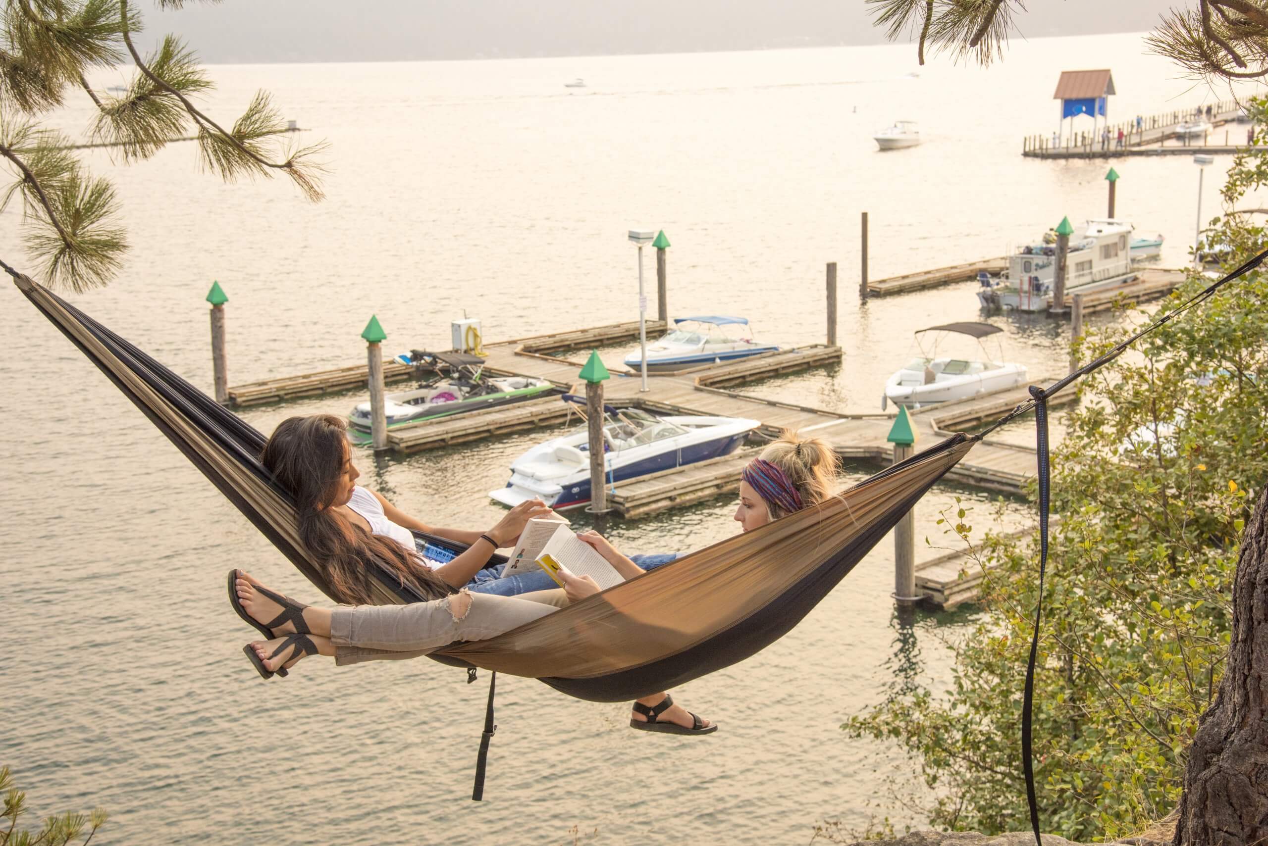 two women read in a hammock overlooking Lake Coeur d'Alene
