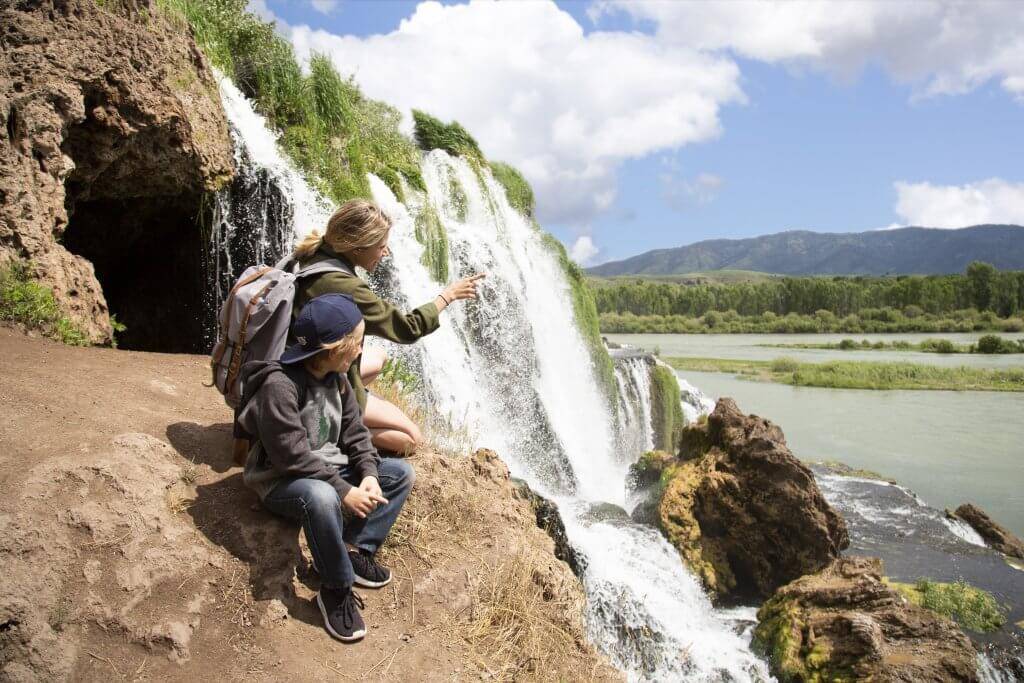 A mother showing her son a waterfall.