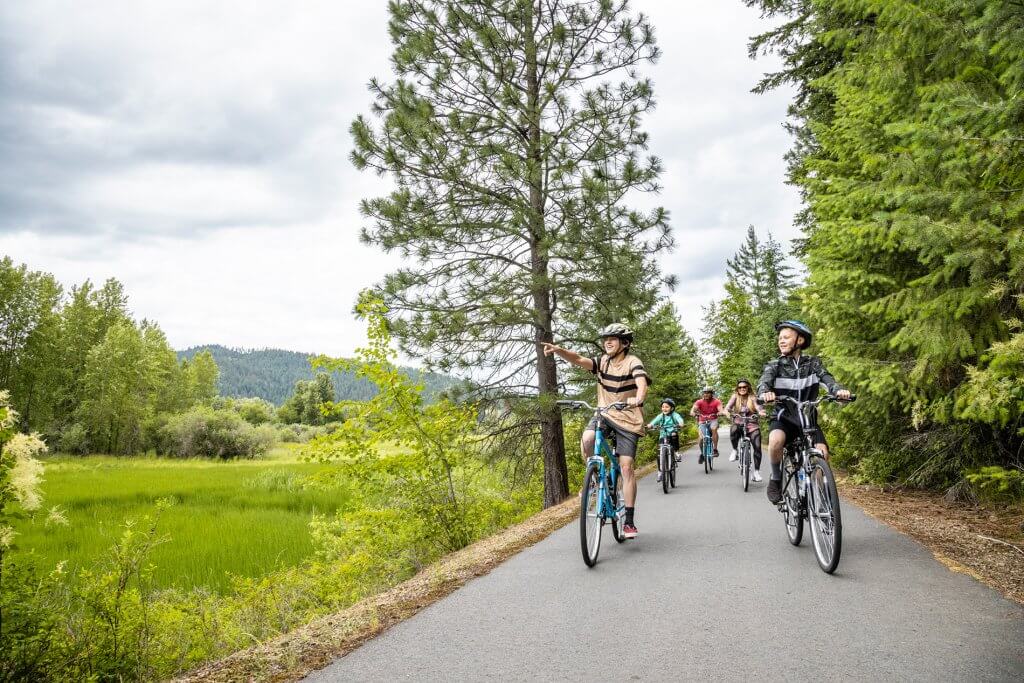 A family rides bikes on the Trail of the Coeur d’Alenes.