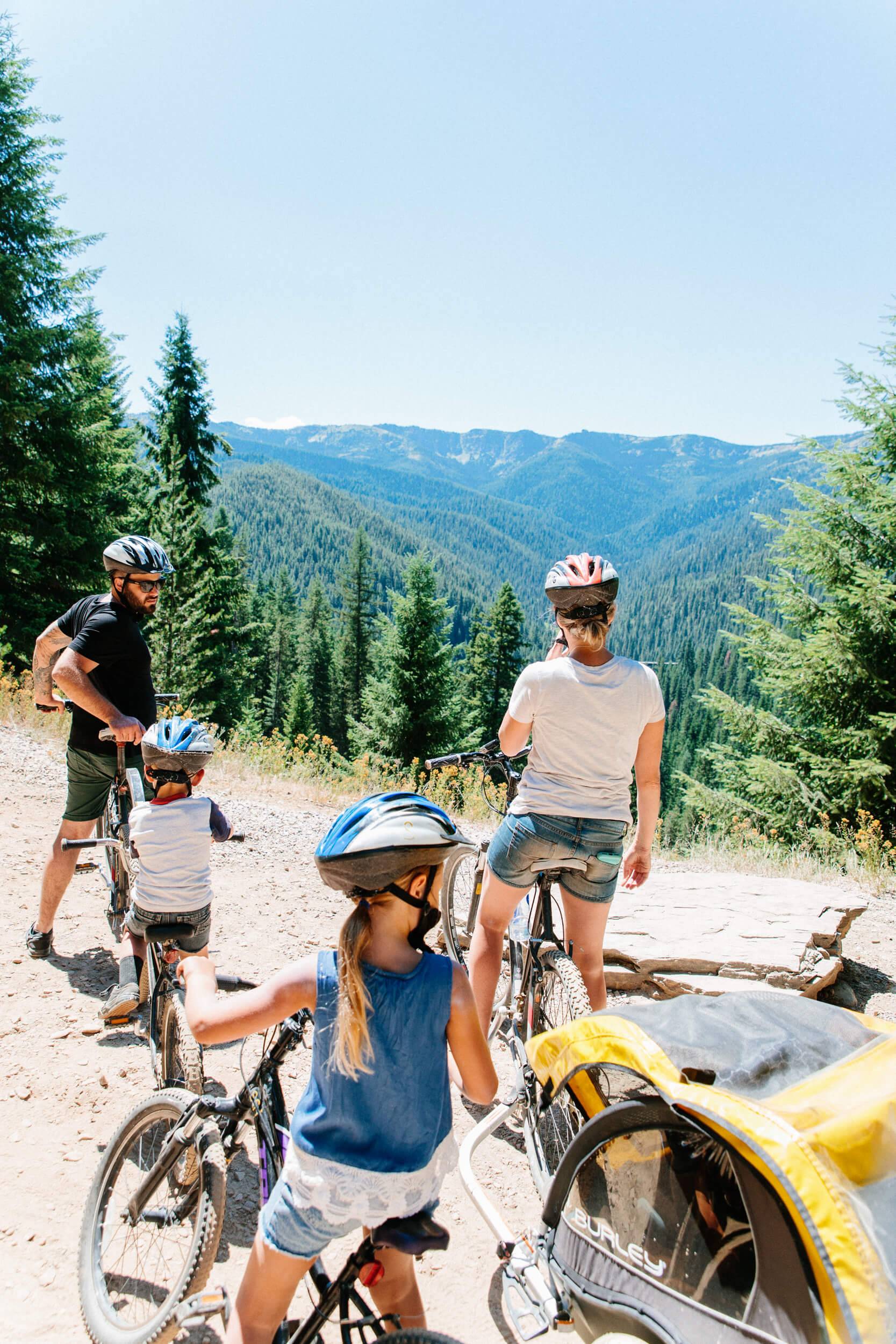a family of four riding bikes, takes a break at an overlook along the Route of the Hiawatha