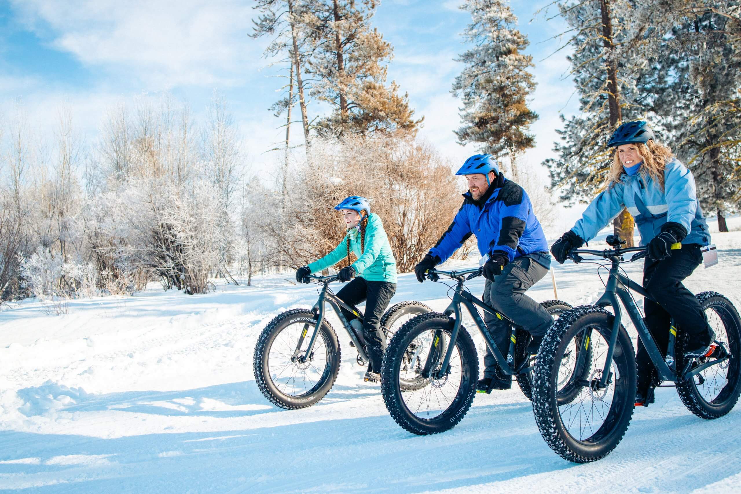 A family of three fat biking together in winter gear near McCall, Idaho, in the winter.