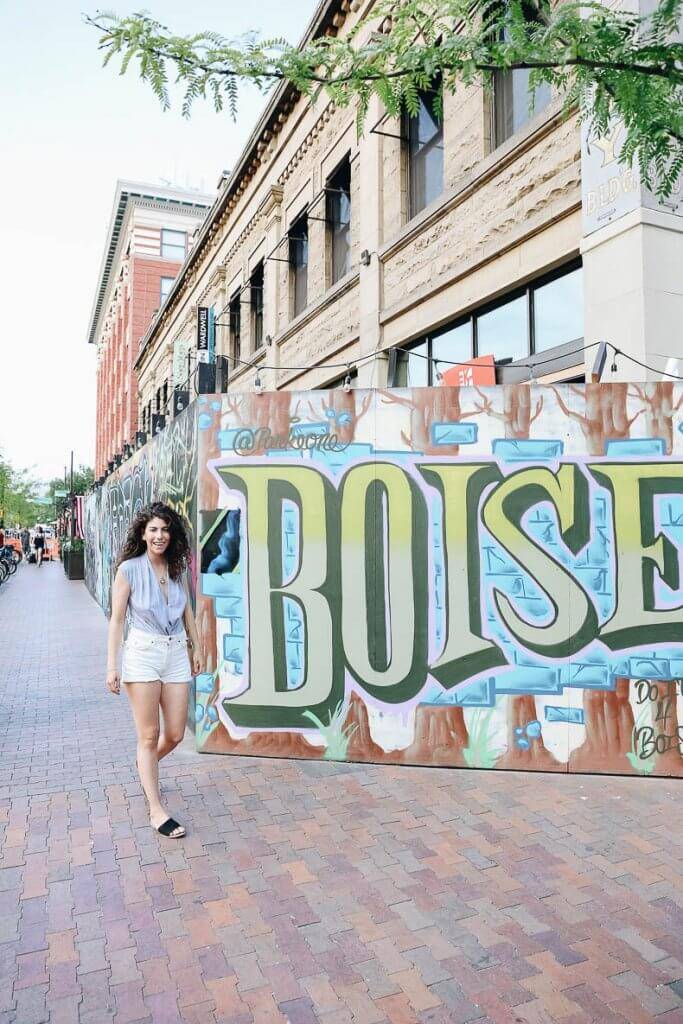 woman standing next a mural