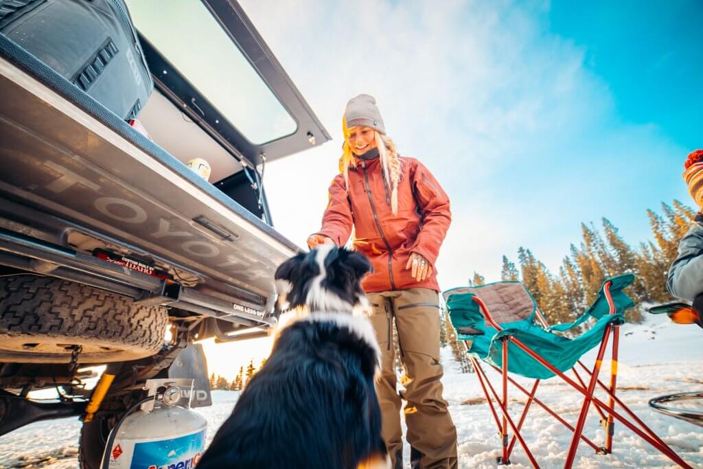A woman and dog taking a break from skiing at Brundage Mountain Resort.