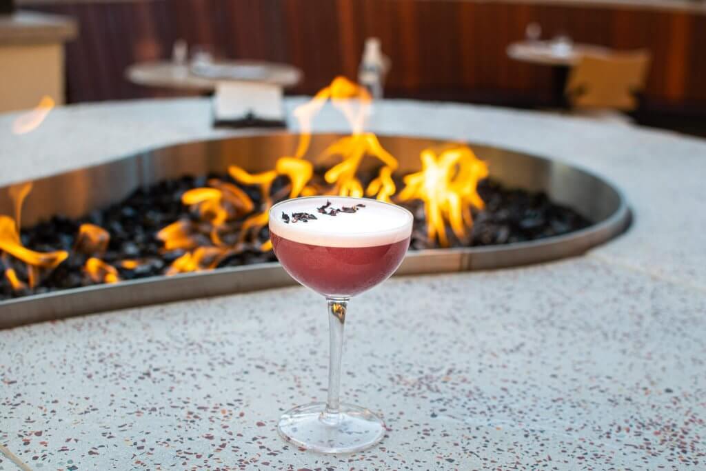 A cocktail from Ochos in Boise, Idaho, by an outdoor firepit.