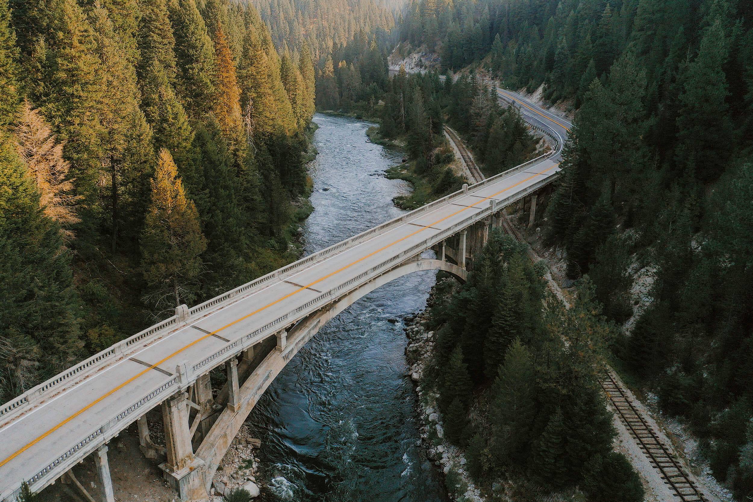 a bridge crossing over a river lined with trees