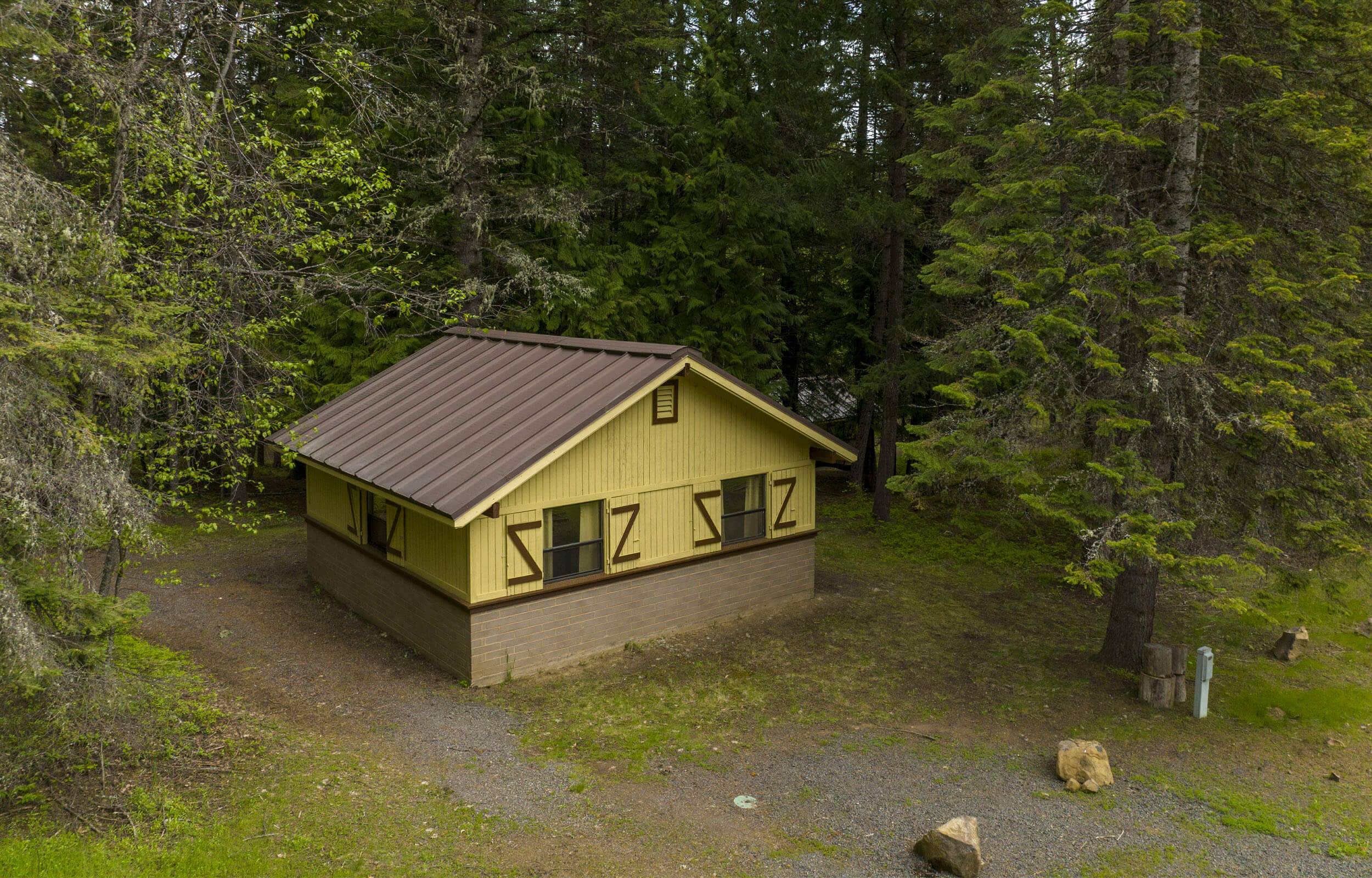 An overhead shot of the Three Meadows Group Campground cabin surrounded by forest.