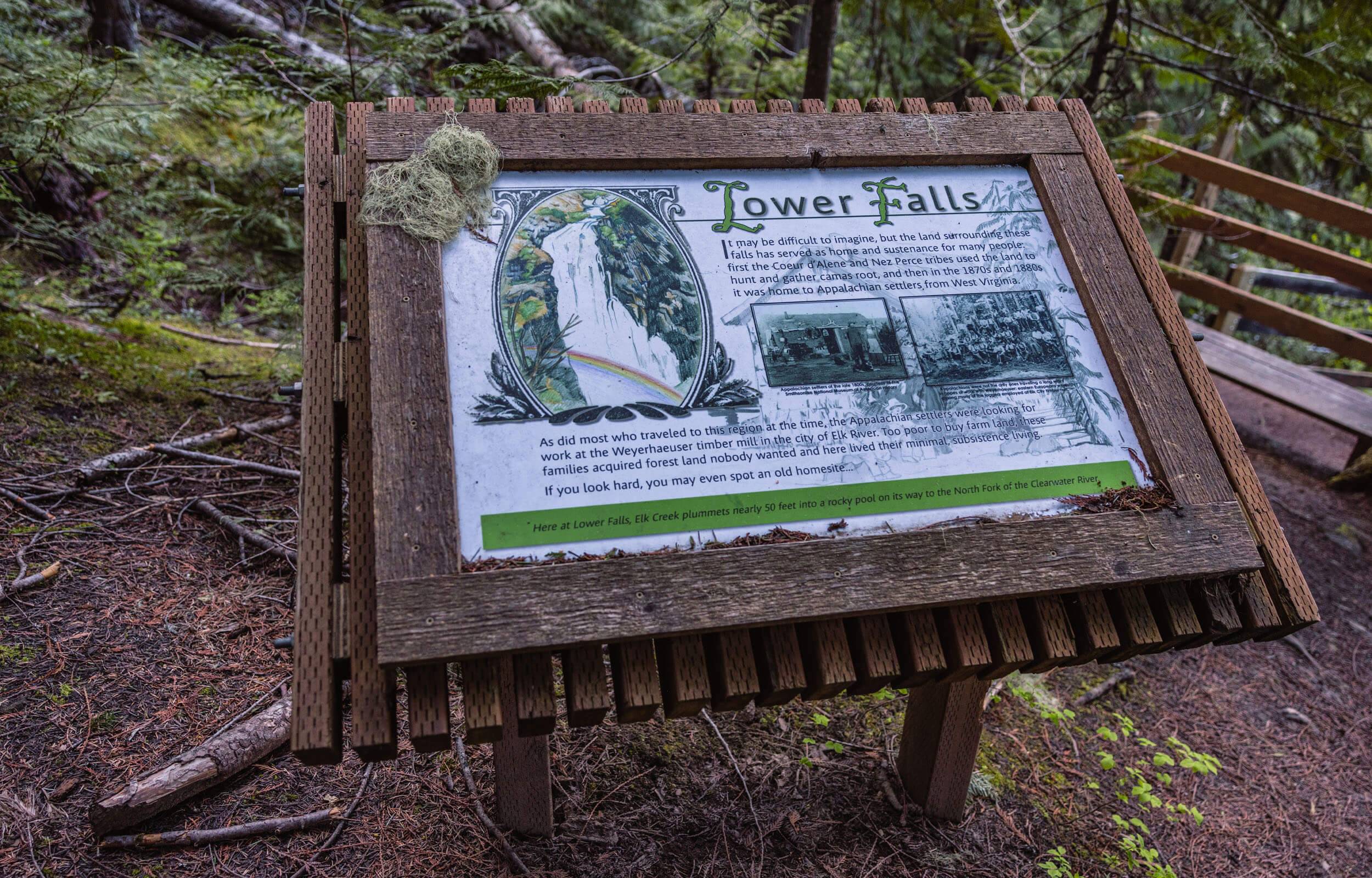 Wooden signage for the Elk Creek Lower Falls sharing history facts.