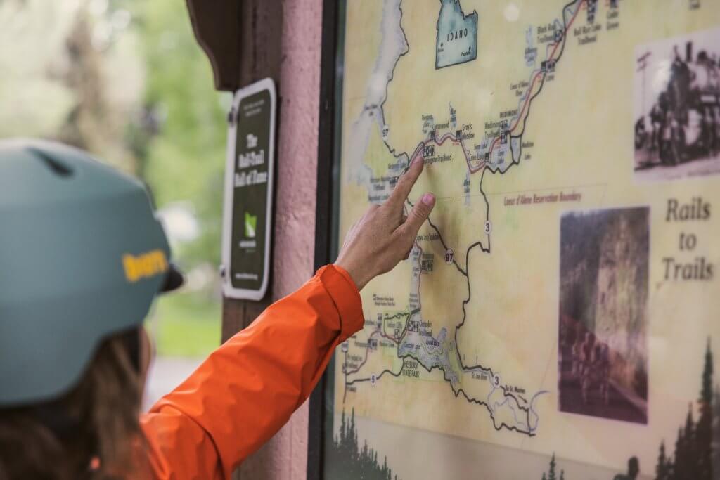 Woman pointing to a location on a trail map.