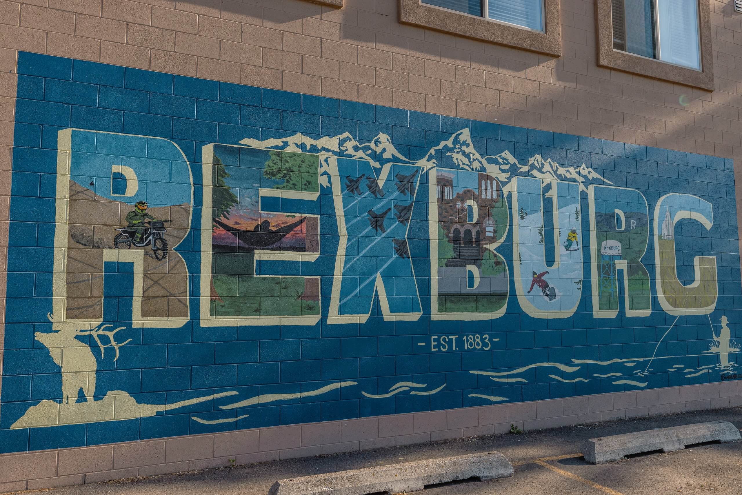 a mural that reads "rexburg" on the wall of a brick building