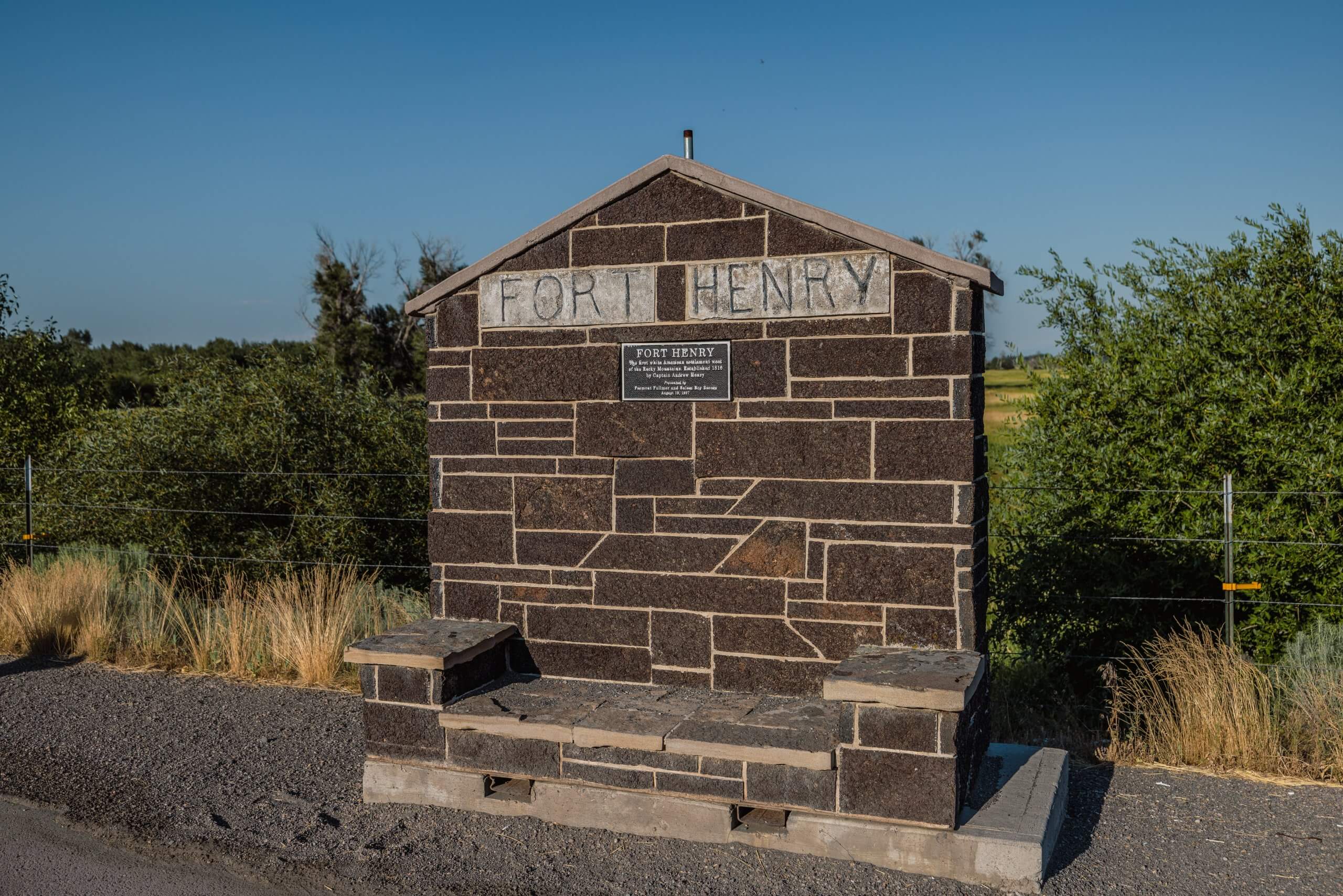 a stone historical marker that reads "fort henry" standing in front of some shrubs