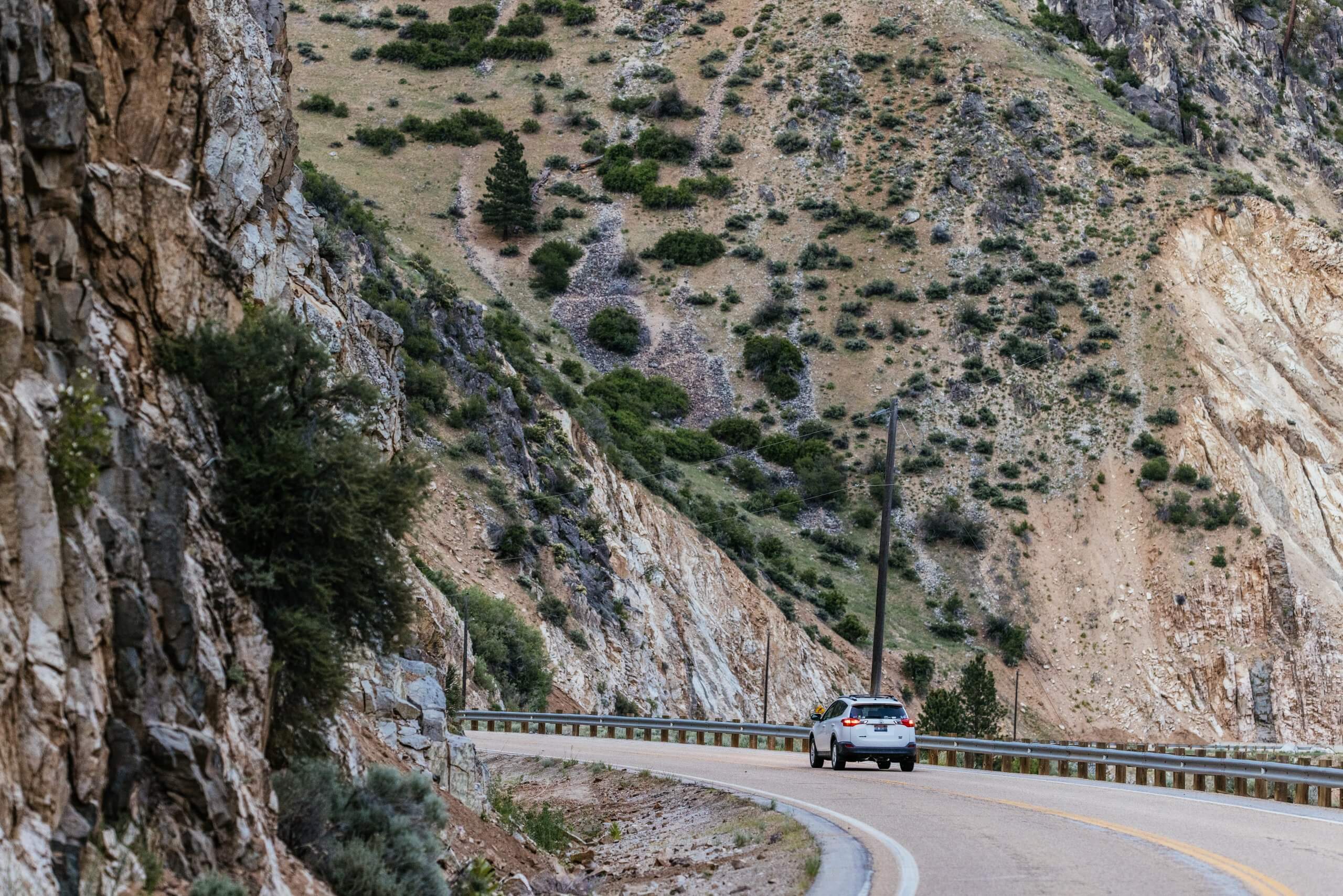 A car drives around a corner in Wildlife Canyon Scenic Byway