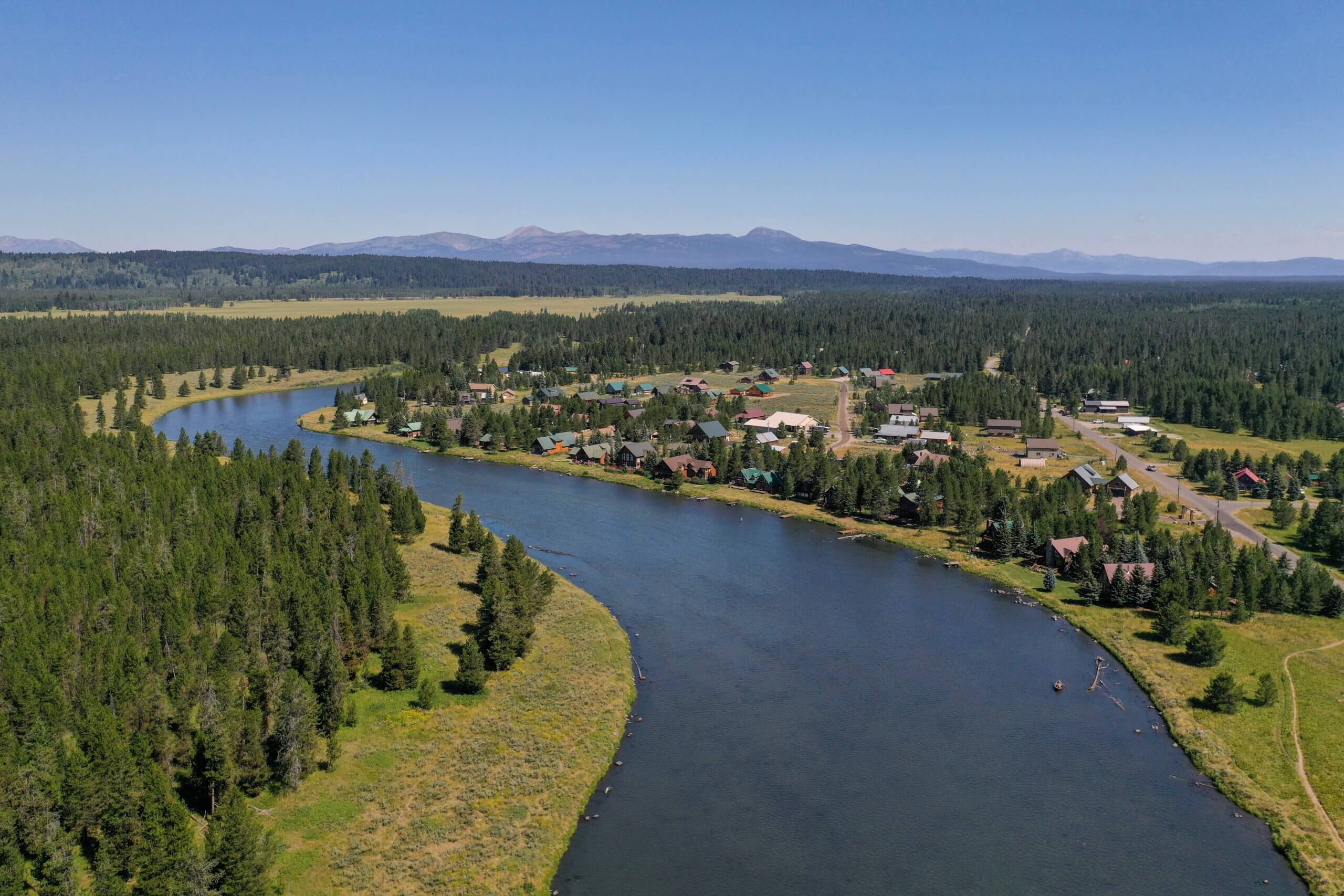henrys fork of the snake river lined by forests and buildings