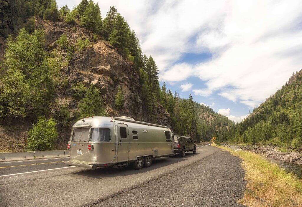 Airstream on the road home with mountain views.