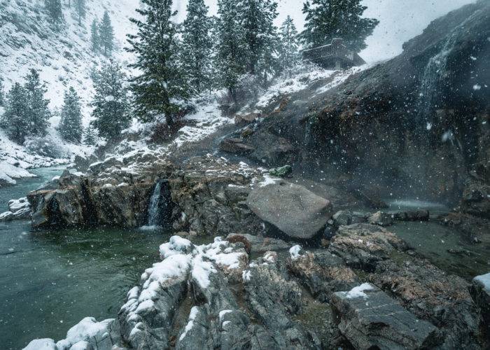 natural hot springs with snow falling