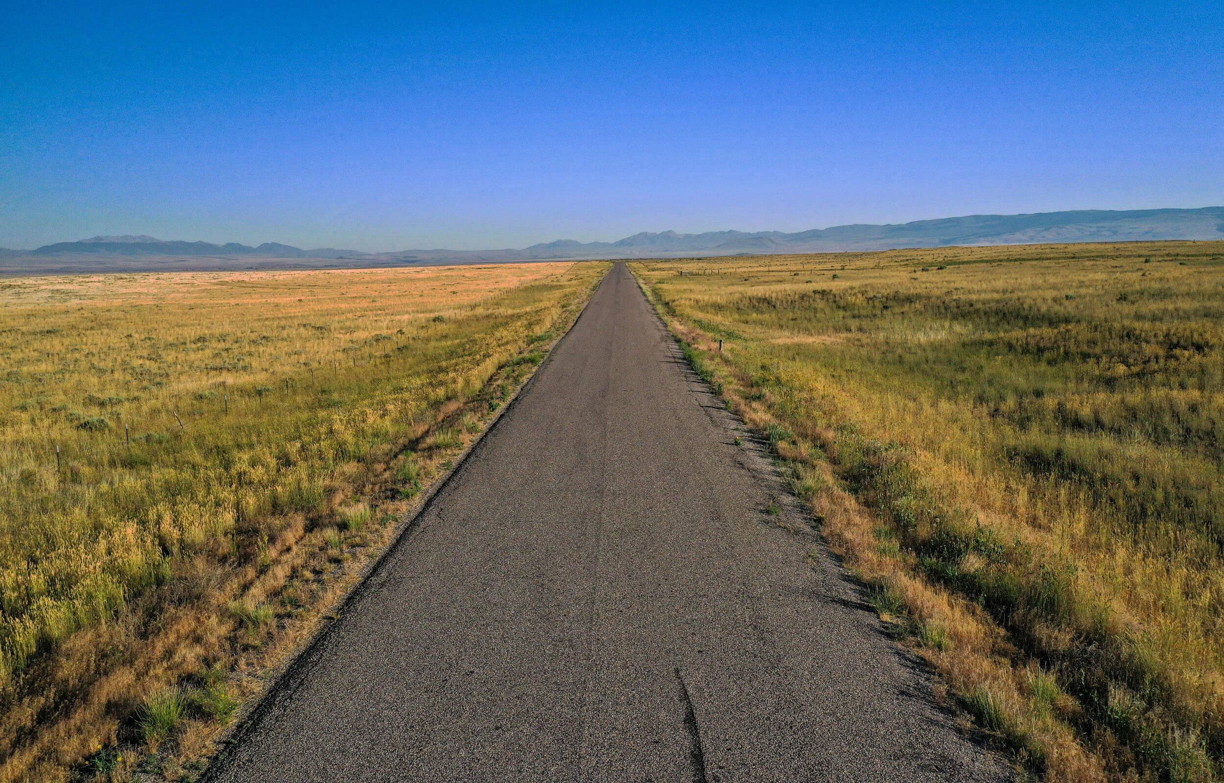 A single lane road surrounded by plains along the Lost Gold Trails Loop.