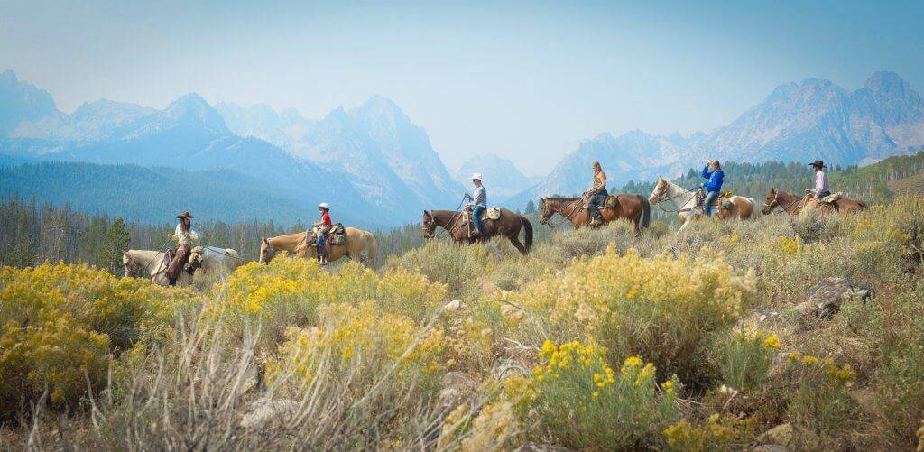Horseback riders with Sawtooth Mountains in the background.