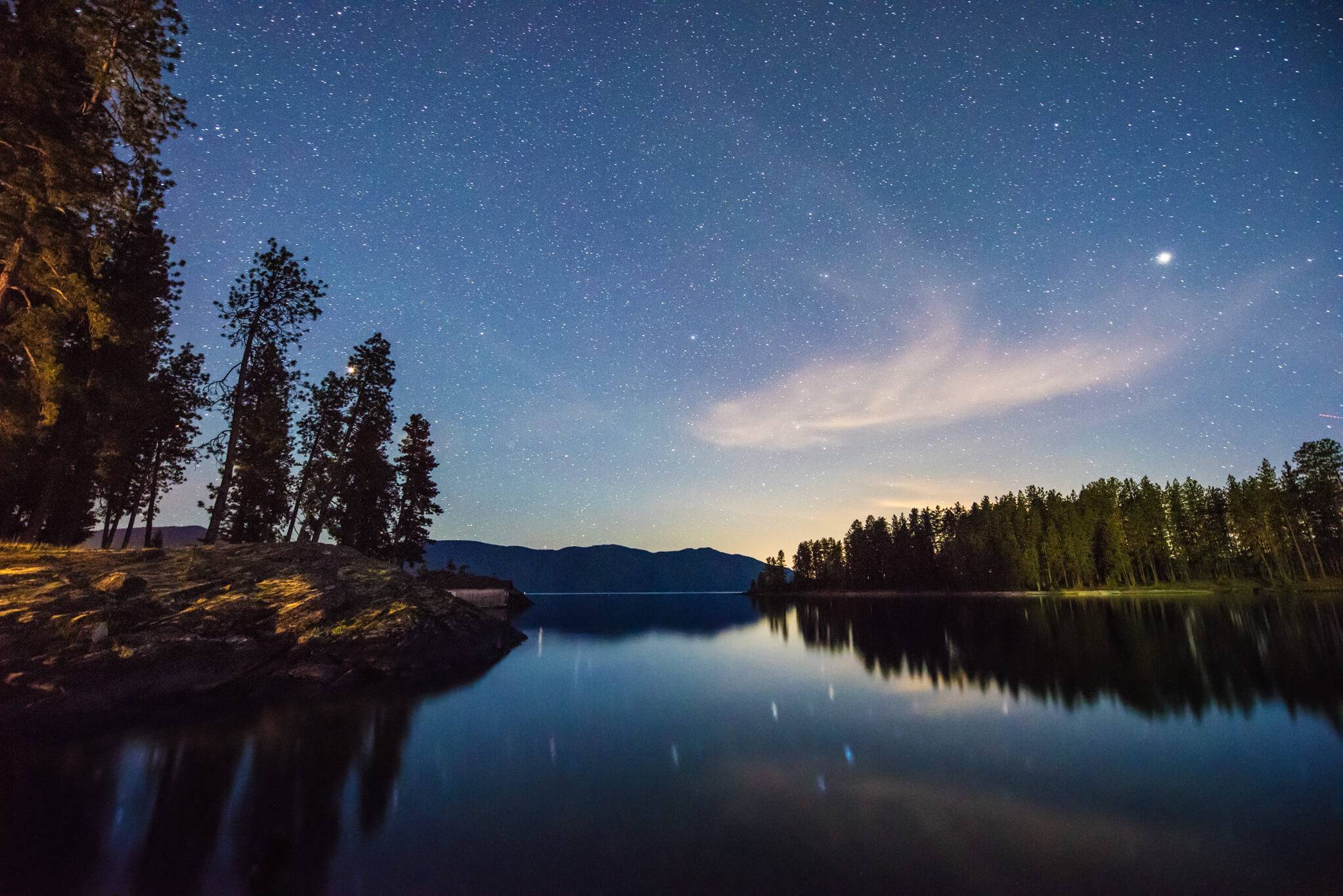 Night sky with galaxies and stars over Lake Pend Oreille.