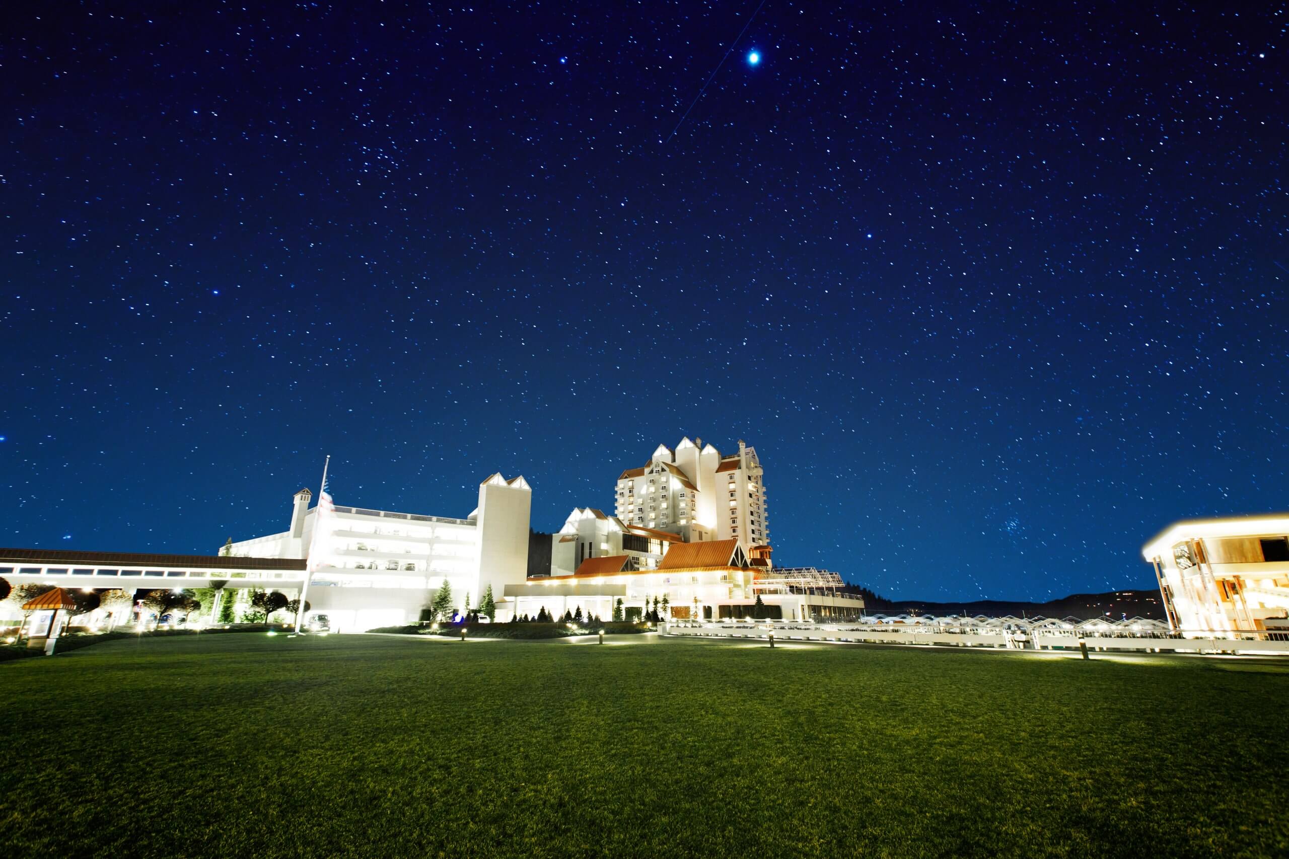 The Coeur d'Alene Resort lit up underneath a starry night sky.
