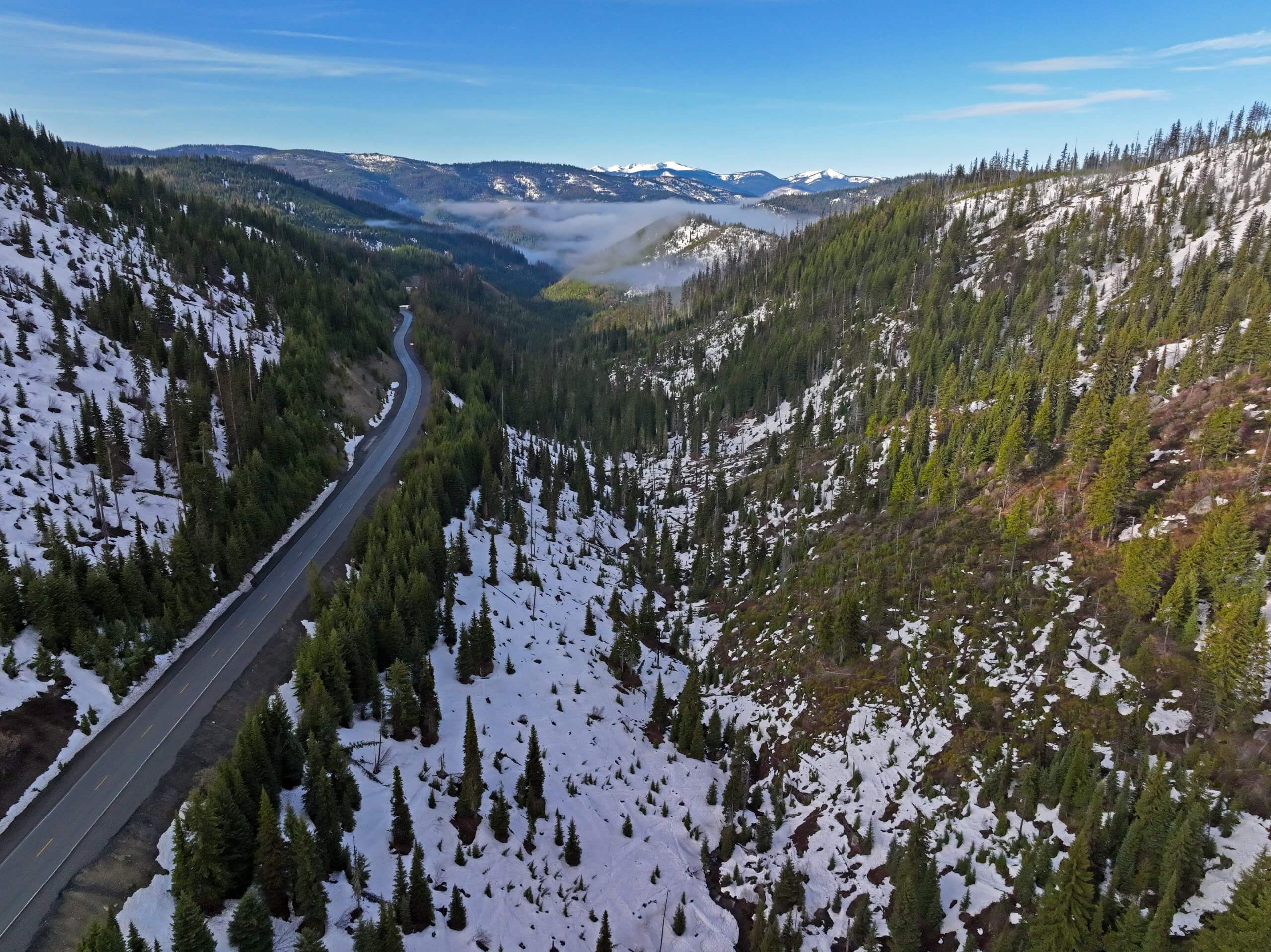 Aerial view of a snowy canyon beside a road.