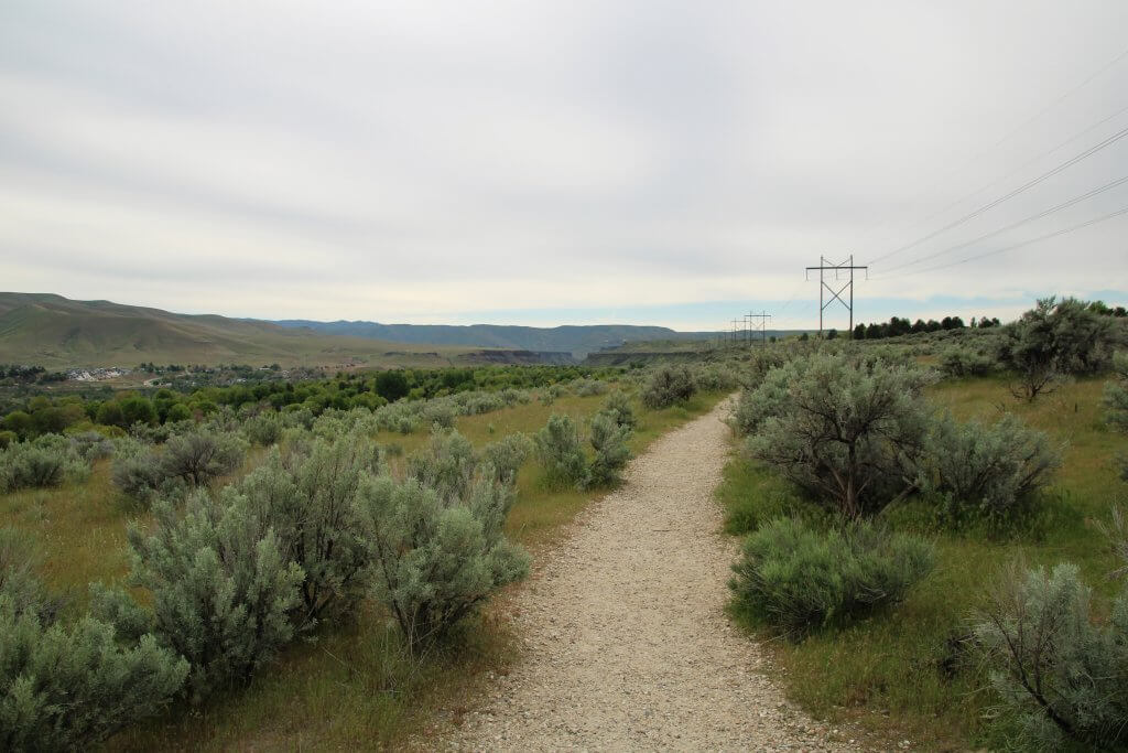 The packed rock trail heads off into the sagebrush and disappears into the distance.