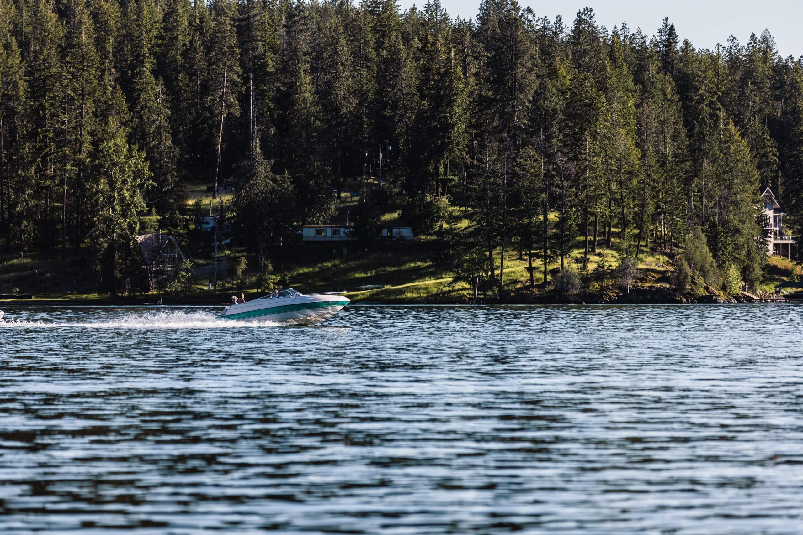 A person drives a speedboat on a lake.