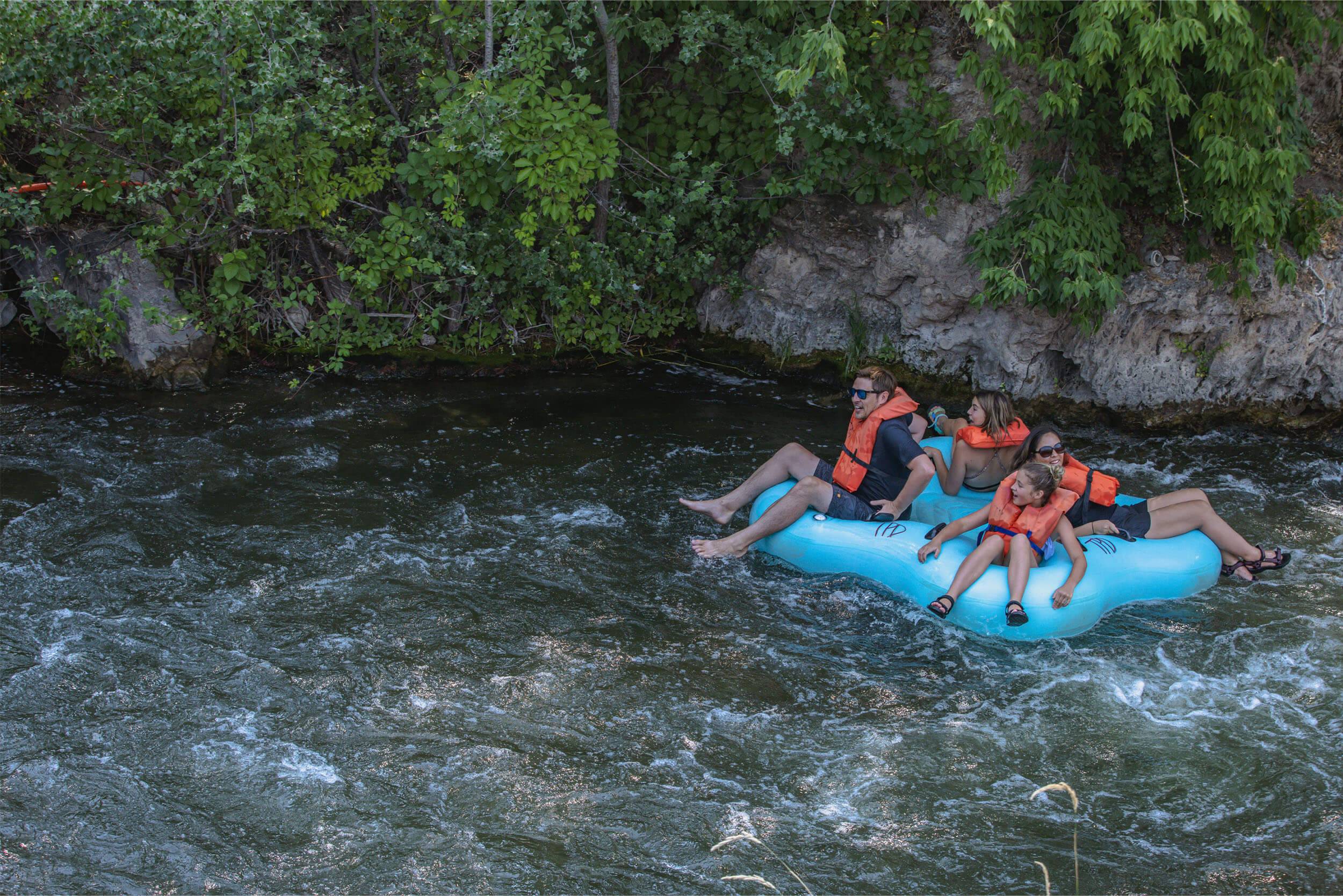A family of four ride a raft down the Portneuf River