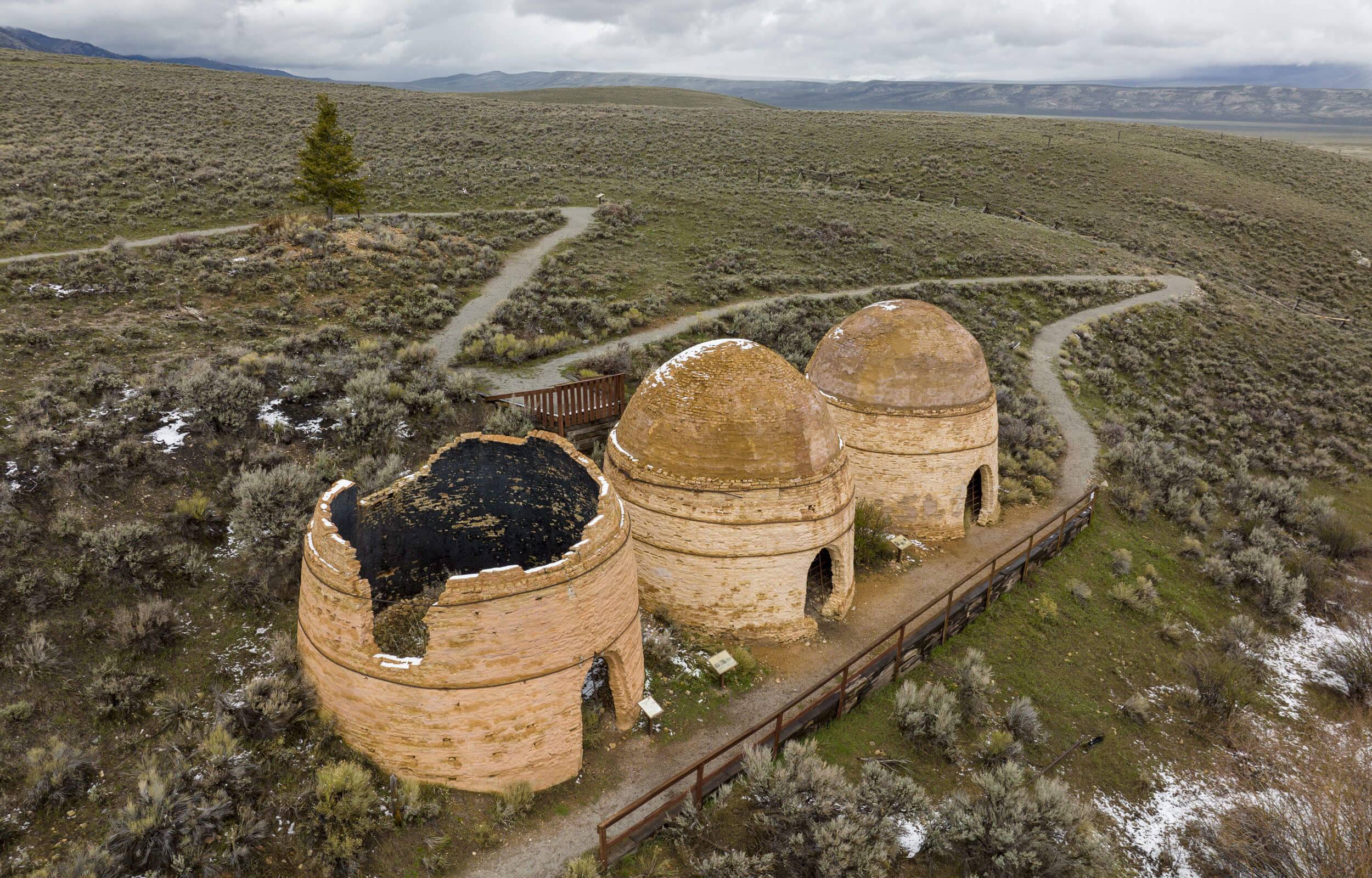 Aerial view of three stone charcoal kilns surrounded by an open landscape of brush, at the Charcoal Kilns Interpretive Site.
