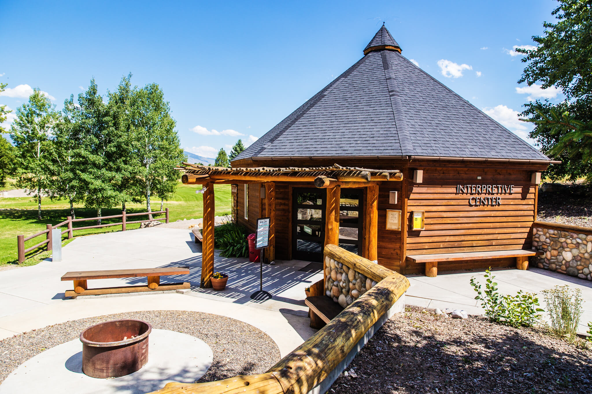 The exterior of the Sacajawea Interpretive, Cultural, and Educational Center and an outdoor firepit area.