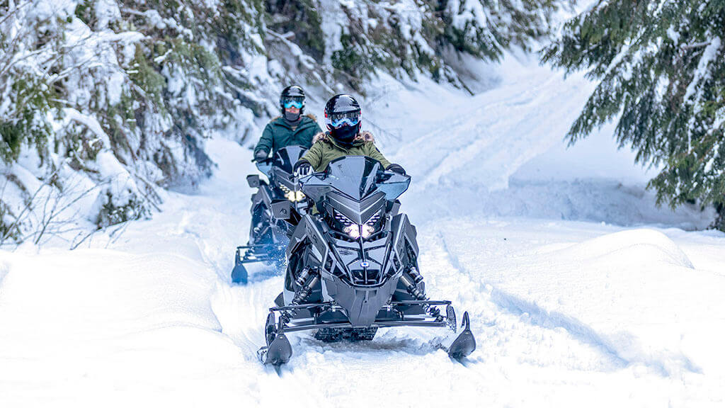 Two people ride snowmobiles at Schweitzer.