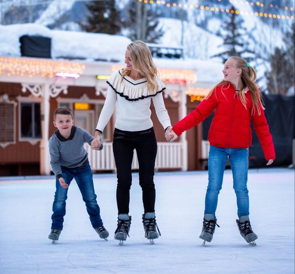A family holds hands while ice skating at the Sun Valley Ice Rink.