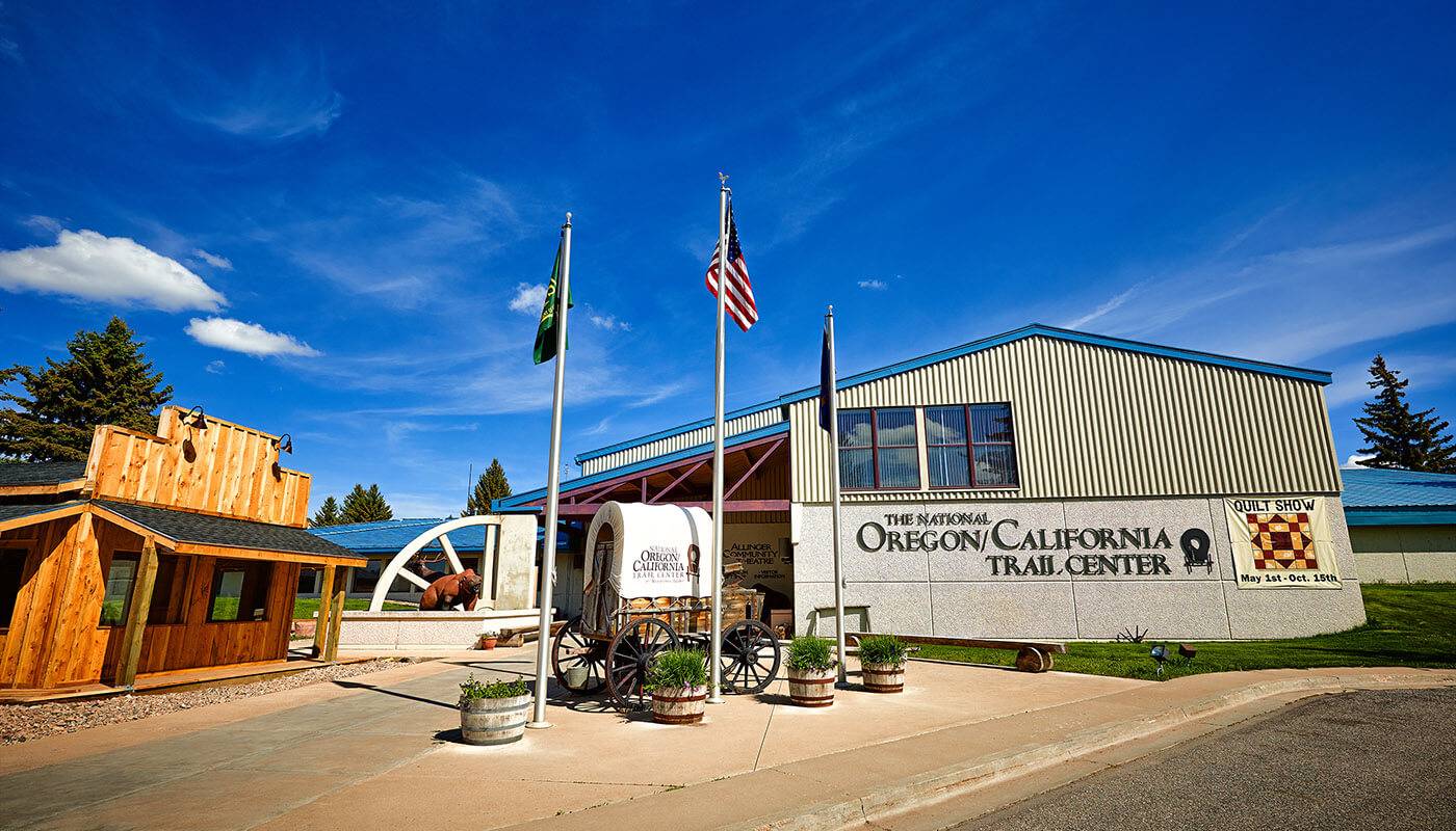 Front view of The National Oregon/California Trail Center building and a small covered wagon.