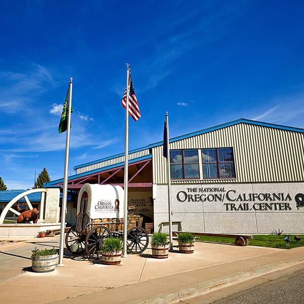 Front view of The National Oregon/California Trail Center building and a small covered wagon.