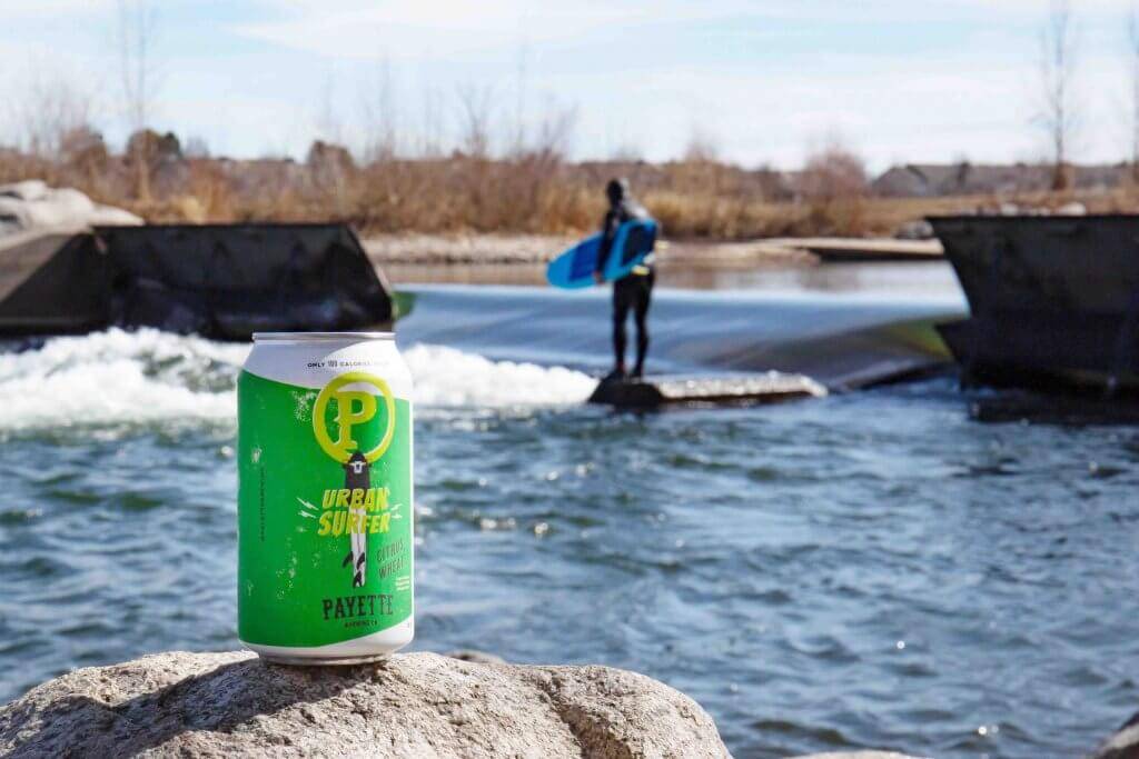 can of beer on a rock by a river